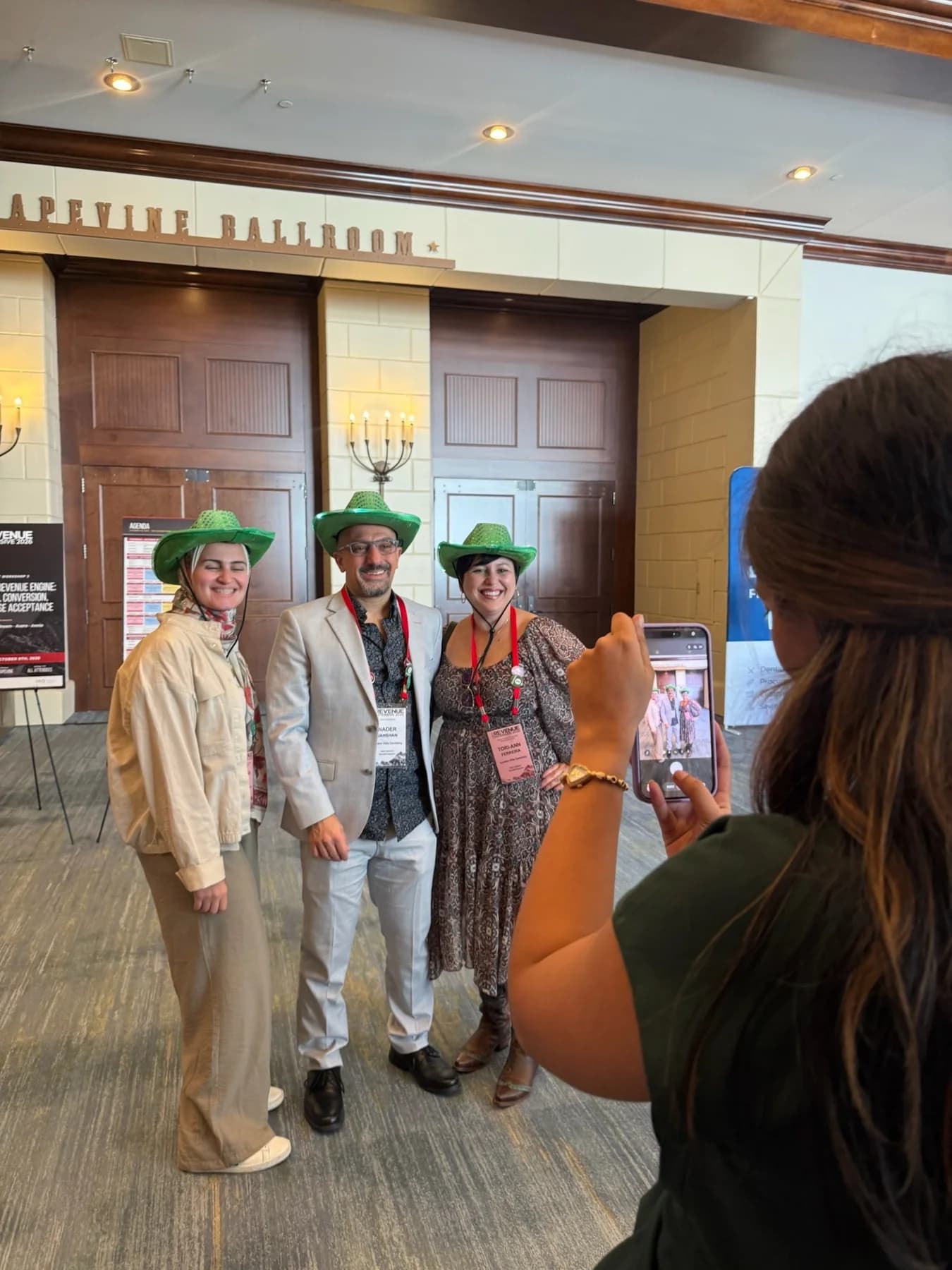 Conference attendees posing together while a colleague takes their photo