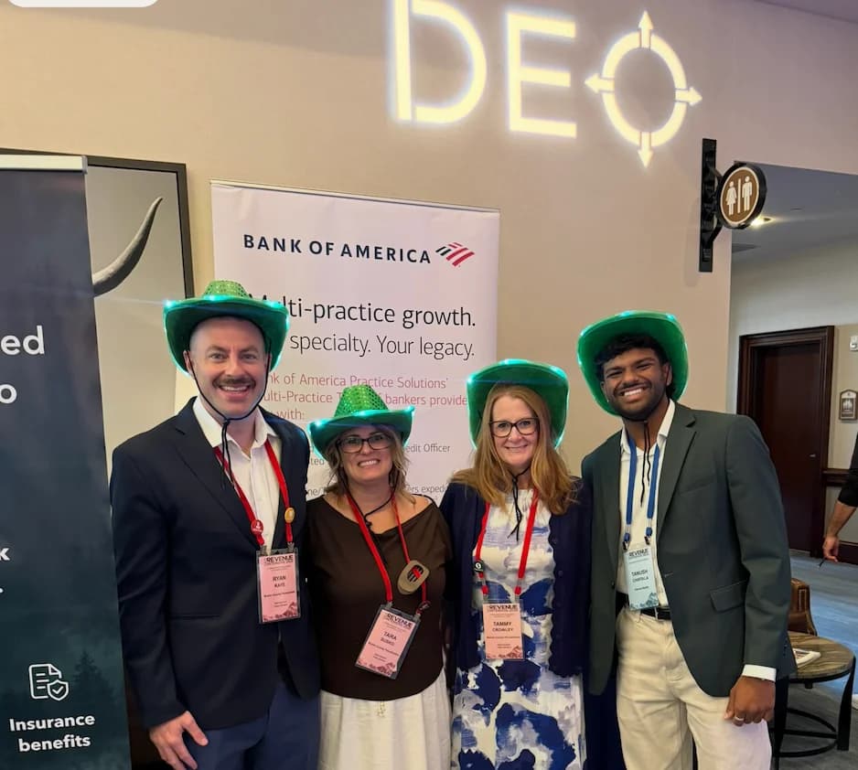 Kairos with conference attendees beneath the DEO sign
